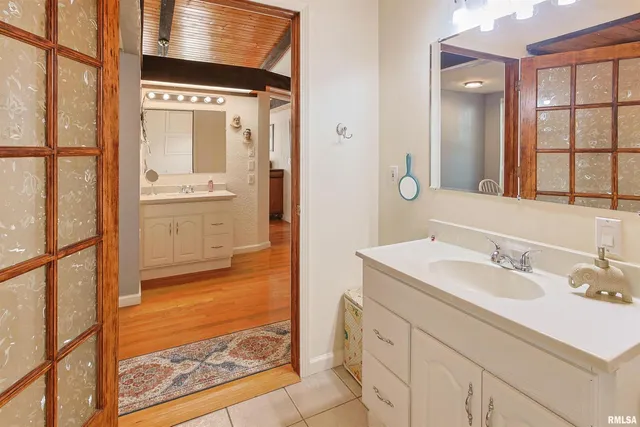 a bathroom with a sink a mirror and a shower