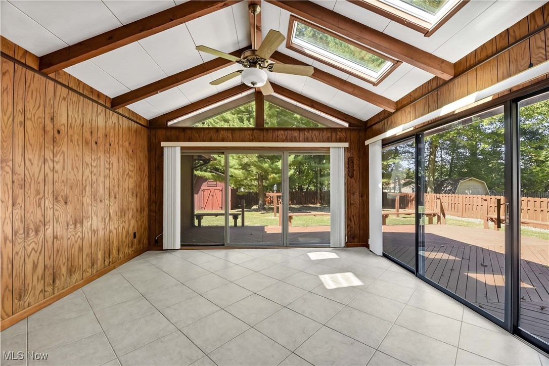 5076 North Barton Road North Ridgeville, OH 44039 - Photo 18 of 41 Unfurnished sunroom with a healthy amount of sunlight, vaulted ceiling with skylight, and ceiling fan