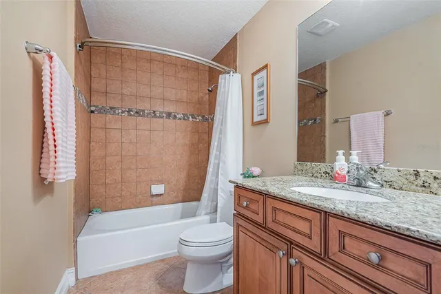 a bathroom with a granite countertop toilet sink and bathtub