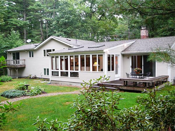 499 Dutton Road Sudbury, MA 01776 - Photo 2 of 21 a front view of a house with a yard table and chairs