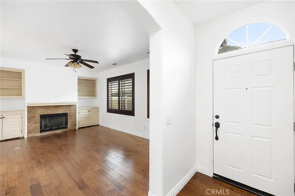 a view of an empty room with a fireplace and a window