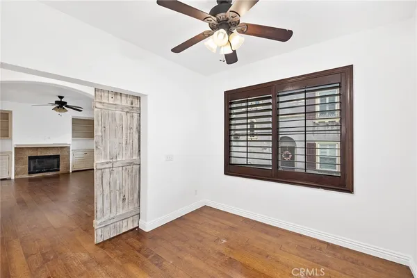 a view of a livingroom with a ceiling fan a fireplace and wooden floor
