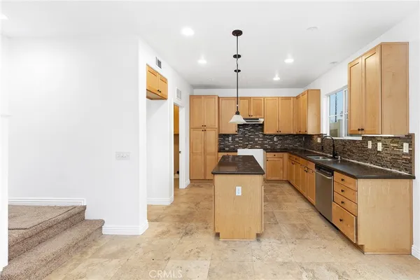a large kitchen with stainless steel appliances granite countertop a stove a sink and a refrigerator