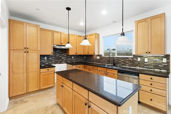 a kitchen with stainless steel appliances granite countertop a sink a stove and a refrigerator