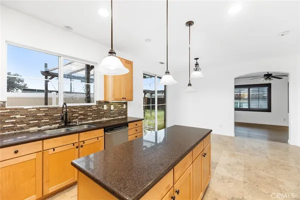 a kitchen with stainless steel appliances granite countertop a sink a stove and a wooden floors