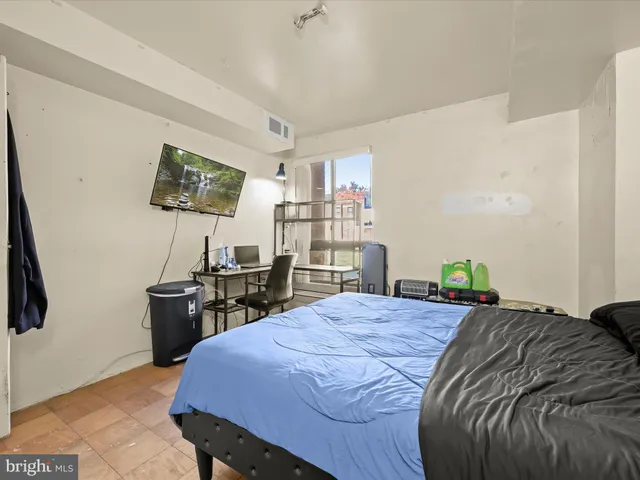 a bedroom with a bed a desk and chair