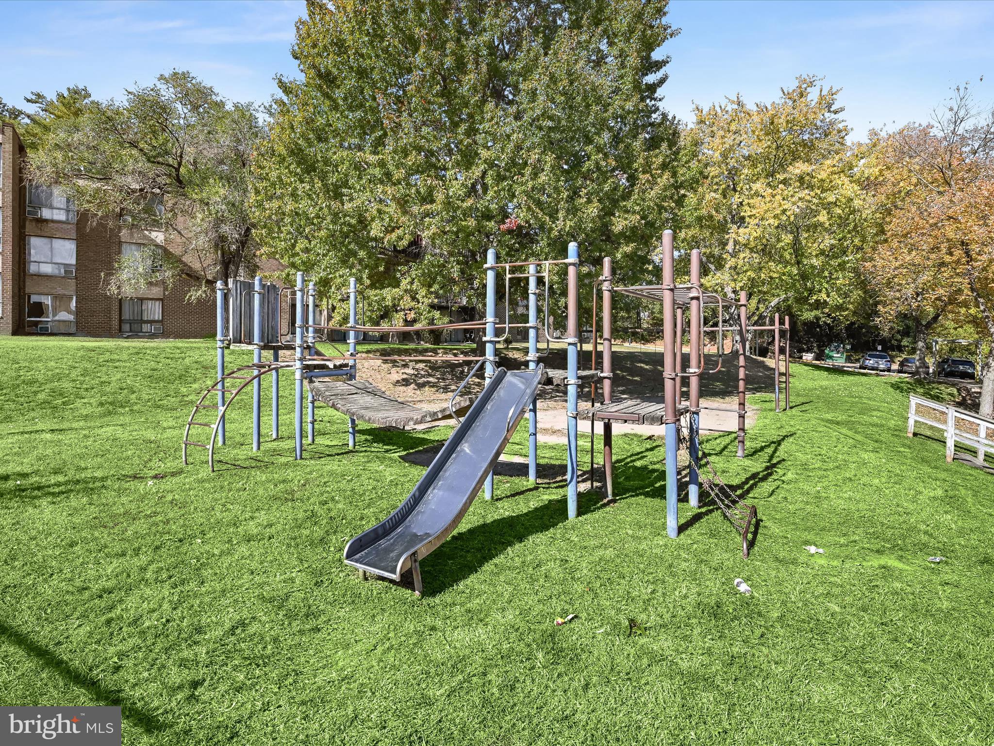7973 Riggs Road, Unit 2 Hyattsville, MD 20783 - Photo 20 of 21 a view of a backyard with a slide trees and wooden fence