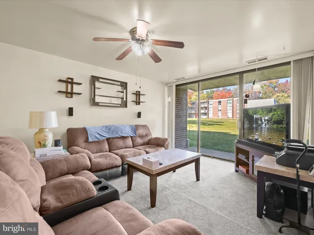 a living room with furniture a flat screen tv and a window
