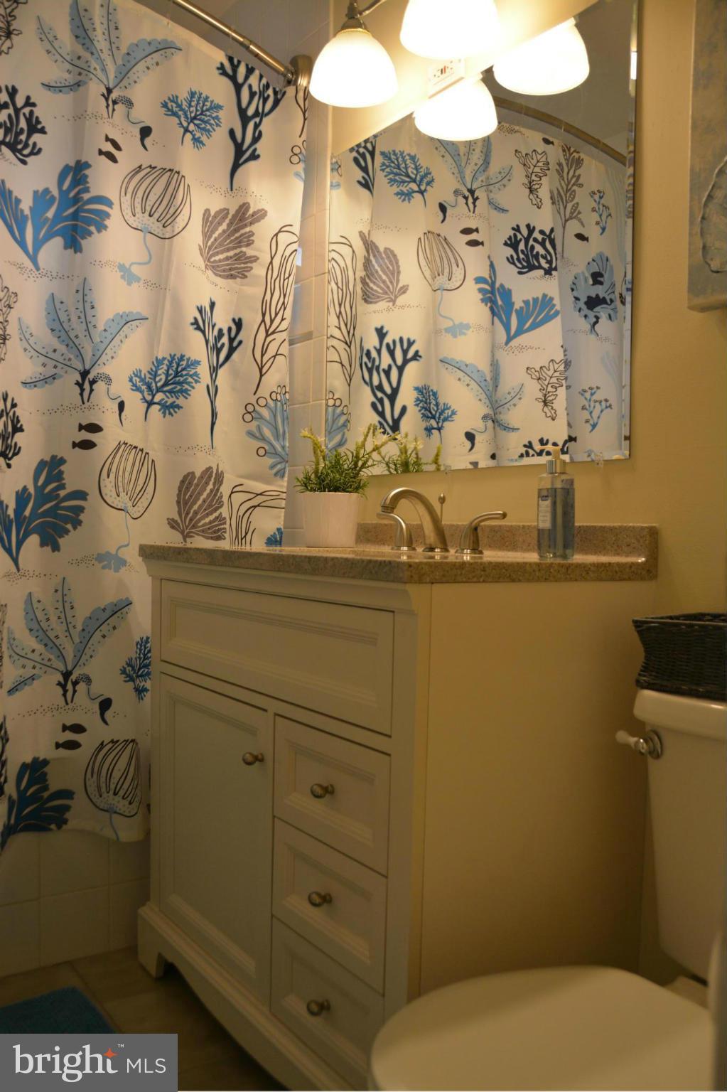 8942 Victoria Road Springfield, VA 22151 - Photo 12 of 25 a bathroom with a toilet sink and mirror