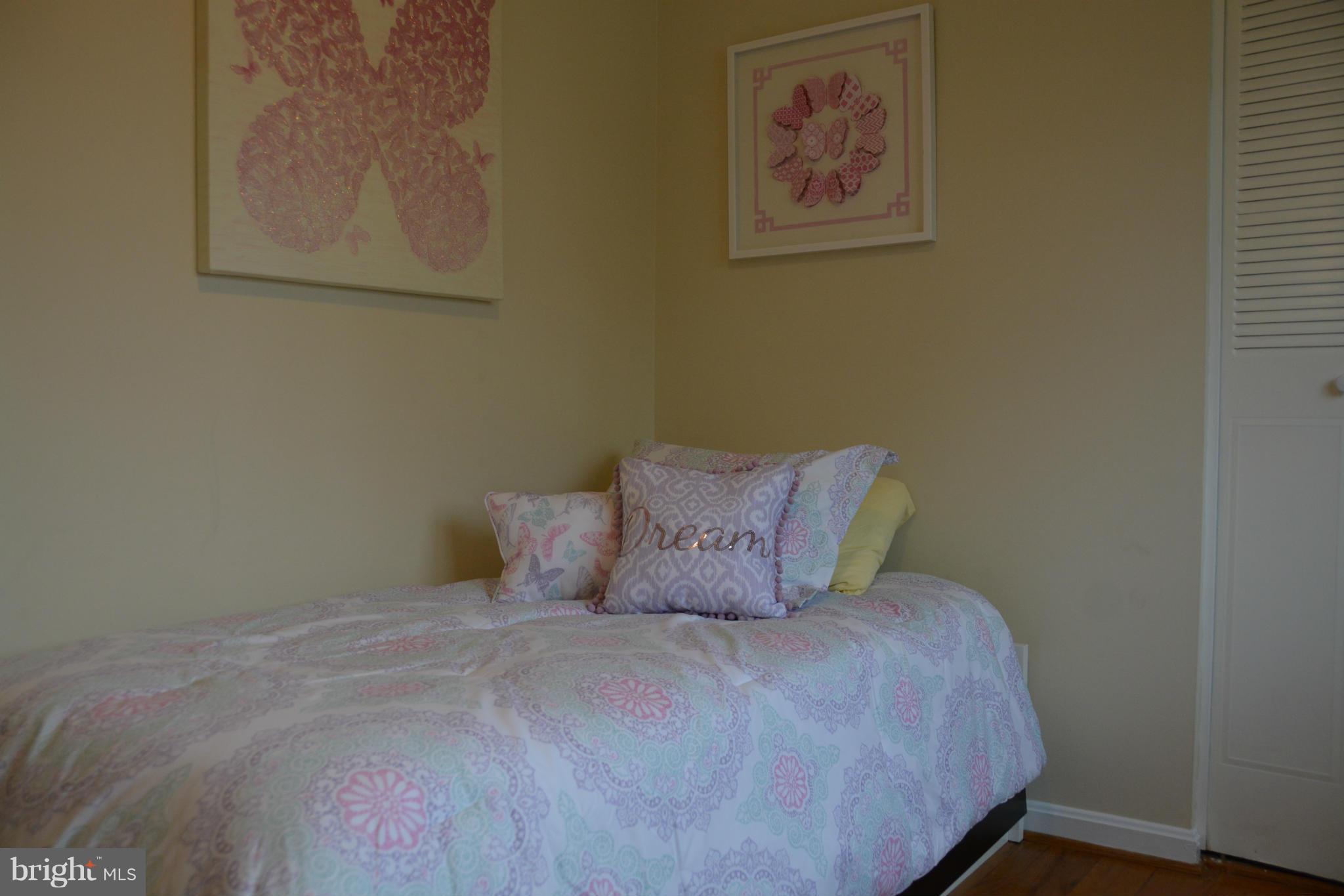 8942 Victoria Road Springfield, VA 22151 - Photo 13 of 25 a large bed sitting in a bedroom next to a wall