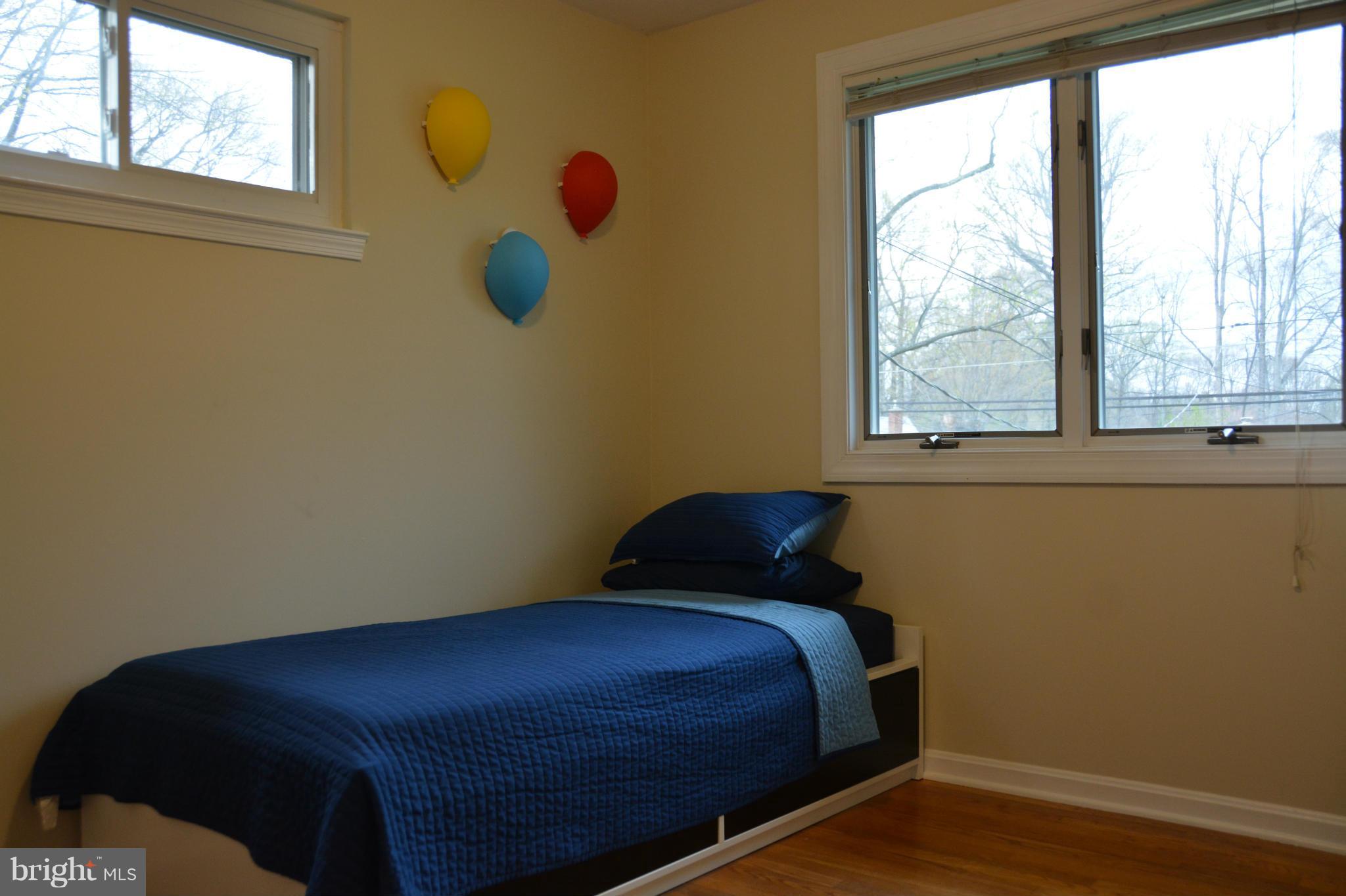 8942 Victoria Road Springfield, VA 22151 - Photo 15 of 25 a bed sitting in a bedroom next to a window