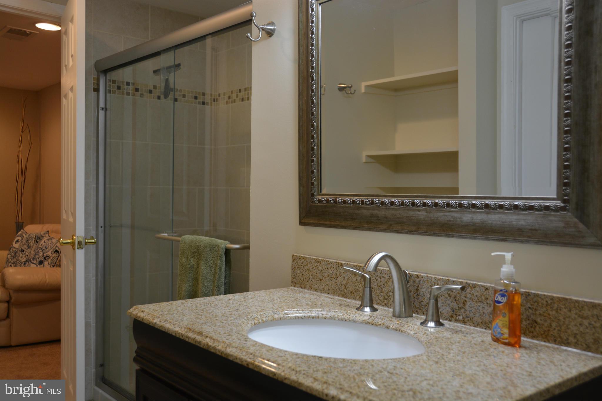 8942 Victoria Road Springfield, VA 22151 - Photo 23 of 25 a bathroom with a granite countertop sink and a mirror