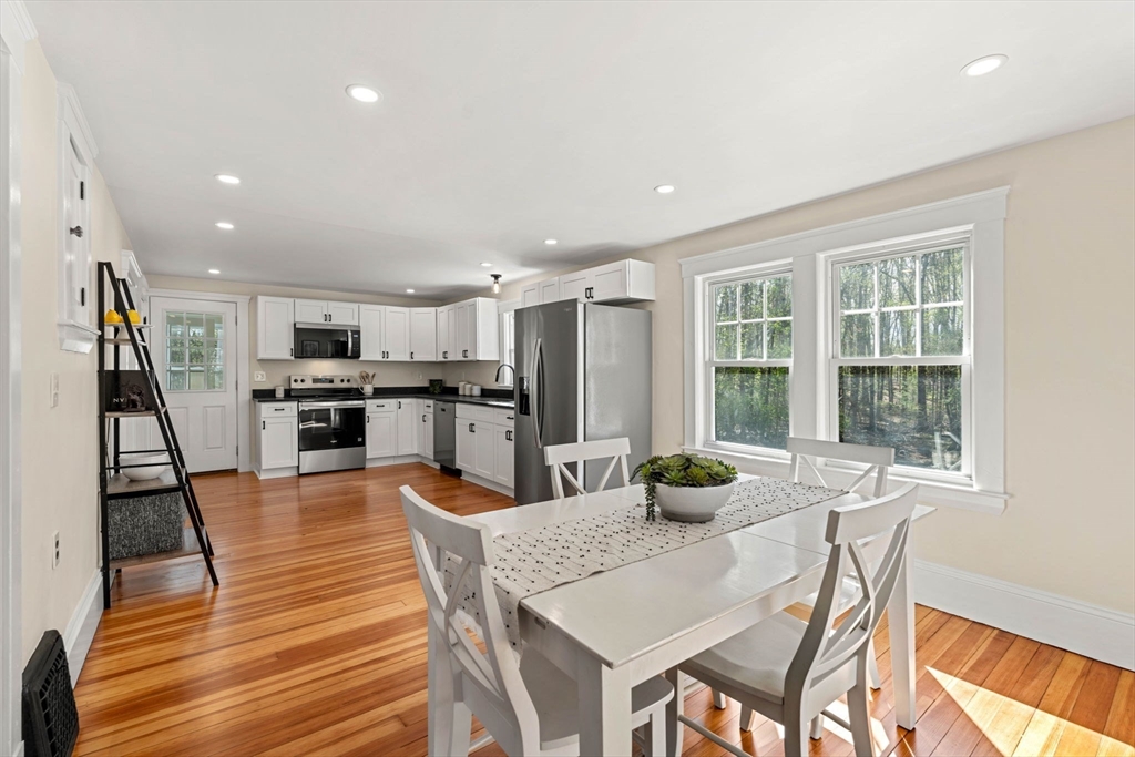 15 Middle Road Amesbury, MA 01913 - Photo 5 of 16 a kitchen with stainless steel appliances wooden floor dining table and chairs