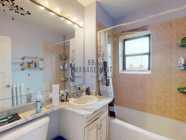 a bathroom with a tub sink and mirror