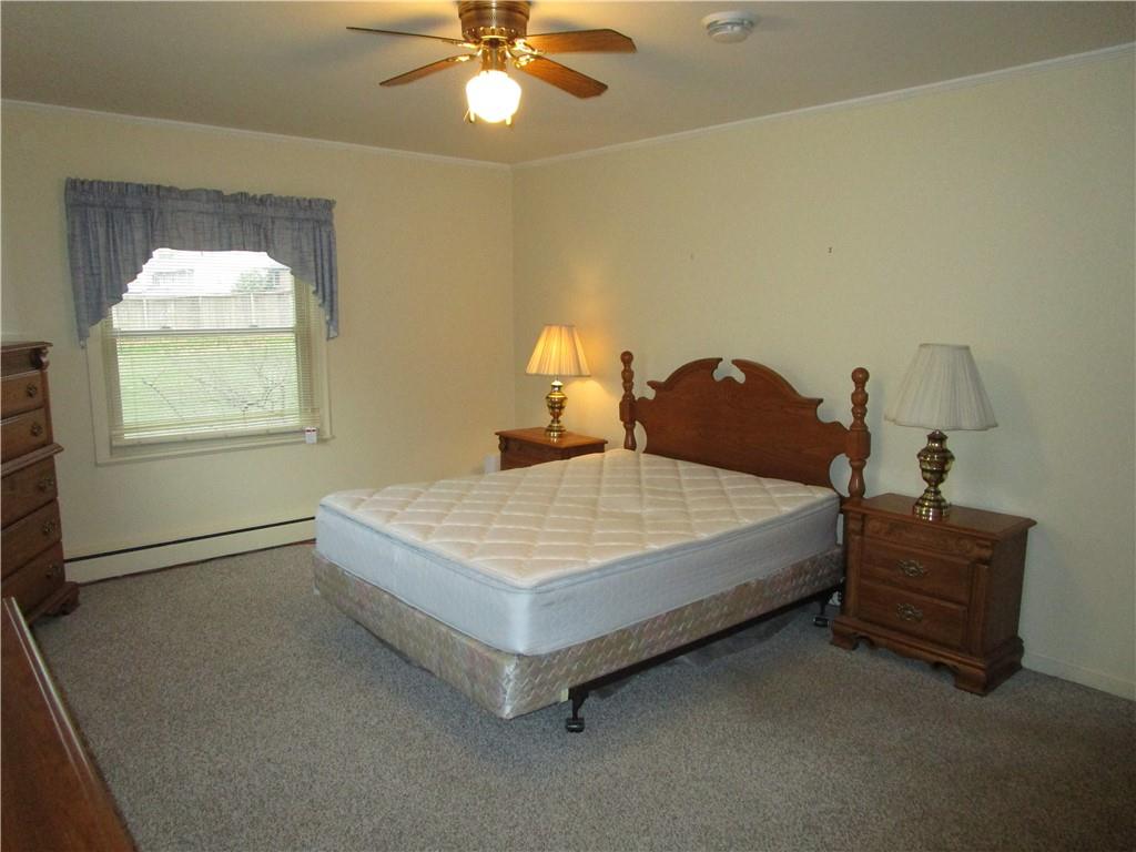 410 Hazen Road Sharpsville, PA 16150 - Photo 13 of 22 a spacious bedroom with a bed and a chandelier