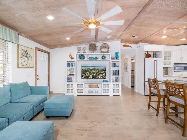 a living room with furniture a flat screen tv and a wall painting