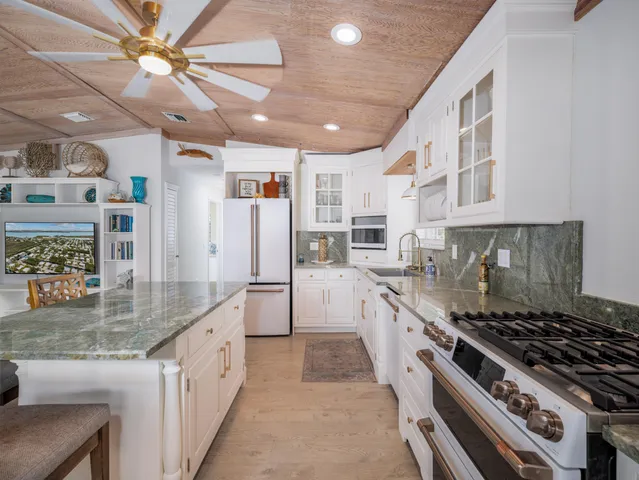 a large kitchen with stainless steel appliances granite countertop a stove and a sink