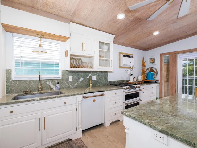 a kitchen with granite countertop a sink stove and cabinets
