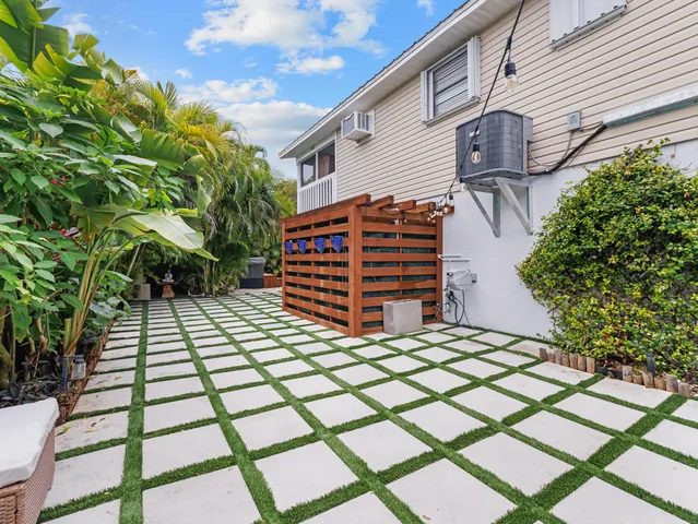 a backyard of a house with potted plants and wooden fence