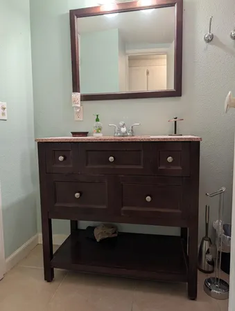 a bathroom with a sink vanity and a mirror