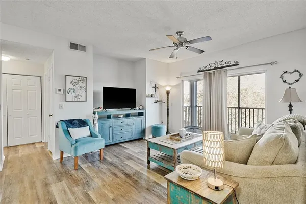 a living room with furniture a flat screen tv and a large window