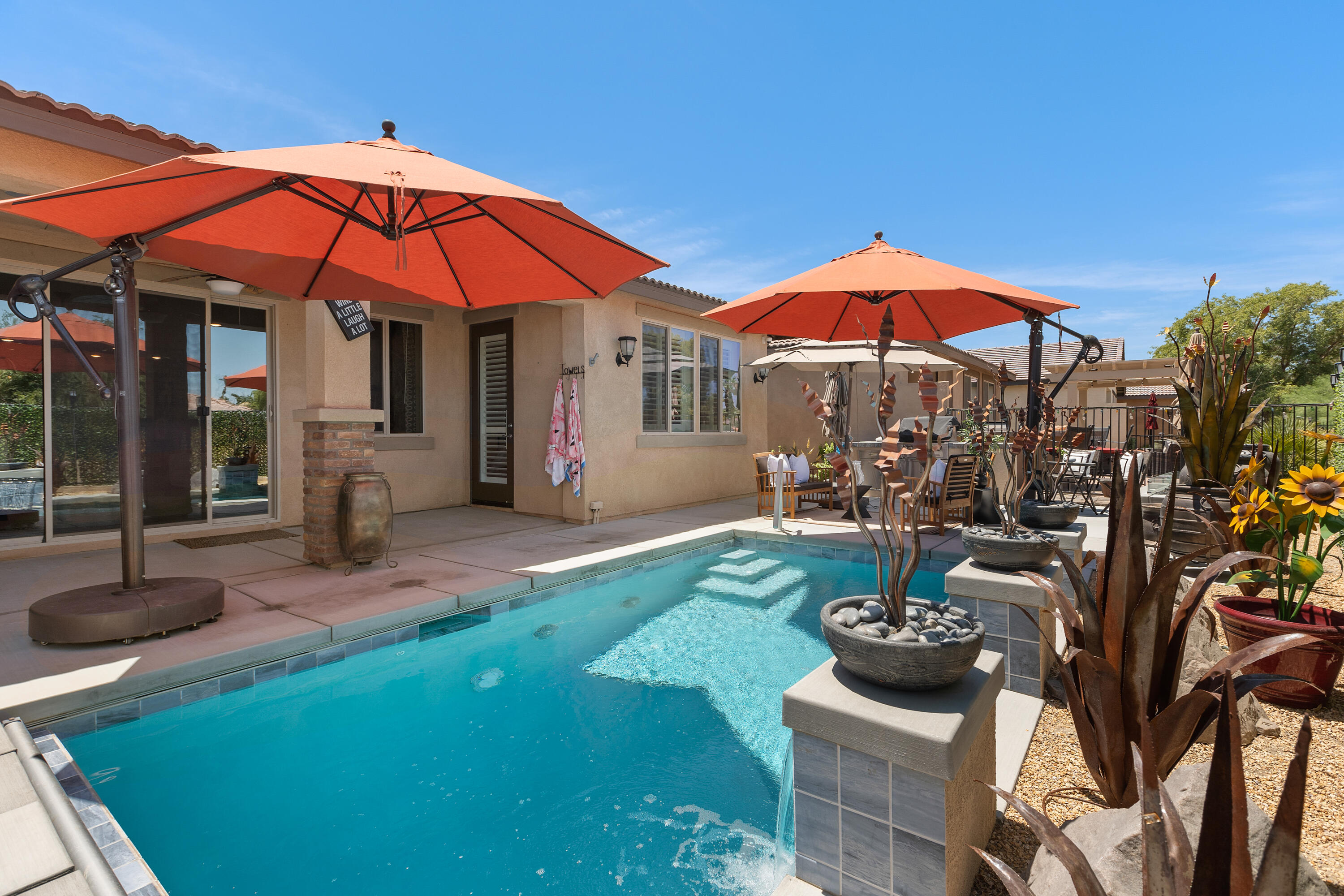 82700 Burnette Drive Indio, CA 92201 - Photo 27 of 38 a view of a patio with chairs and table under an umbrella