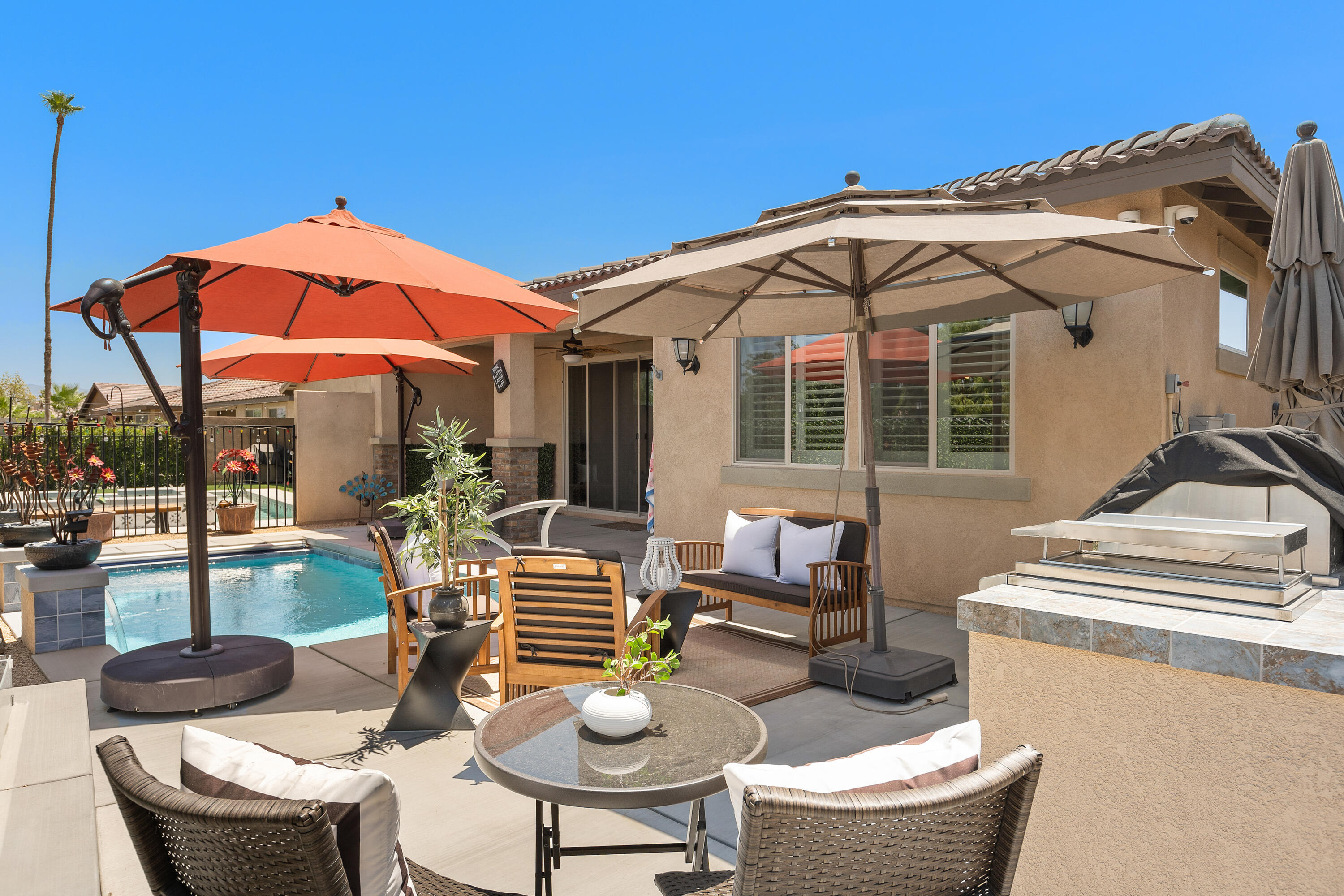 82700 Burnette Drive Indio, CA 92201 - Photo 31 of 38 a patio with a table and chairs under an umbrella