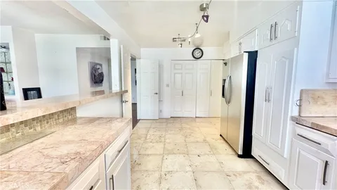 a view of a hallway with wooden floor and a bathroom