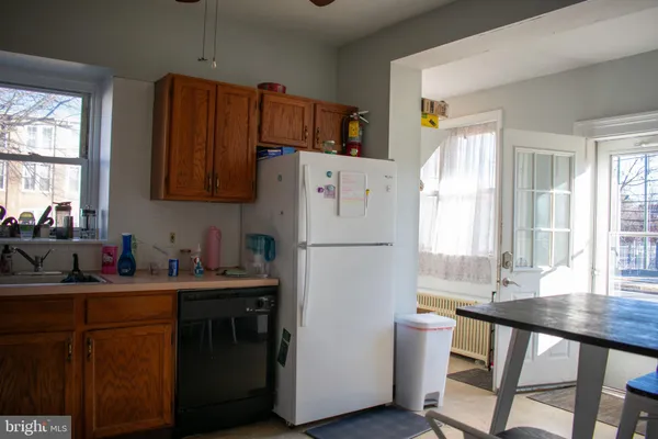 a white kitchen with a window a sink and a refrigerator