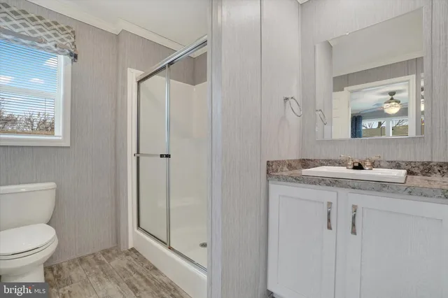 a bathroom with a granite countertop sink toilet and shower
