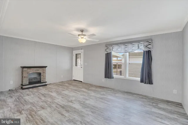 a view of an empty room with a fireplace and a window
