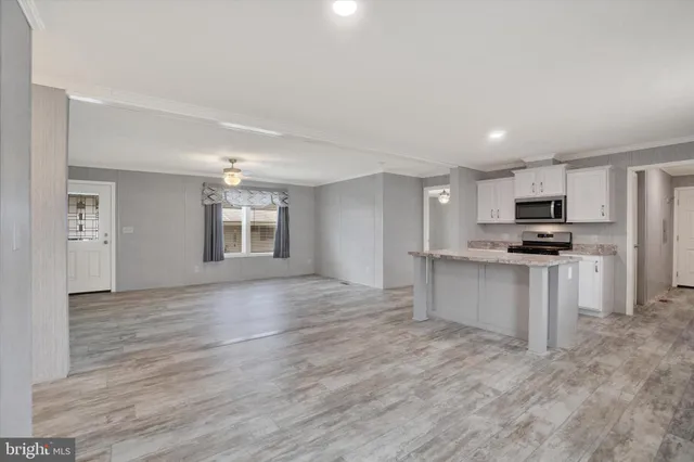 a view of kitchen with granite countertop cabinets and refrigerator