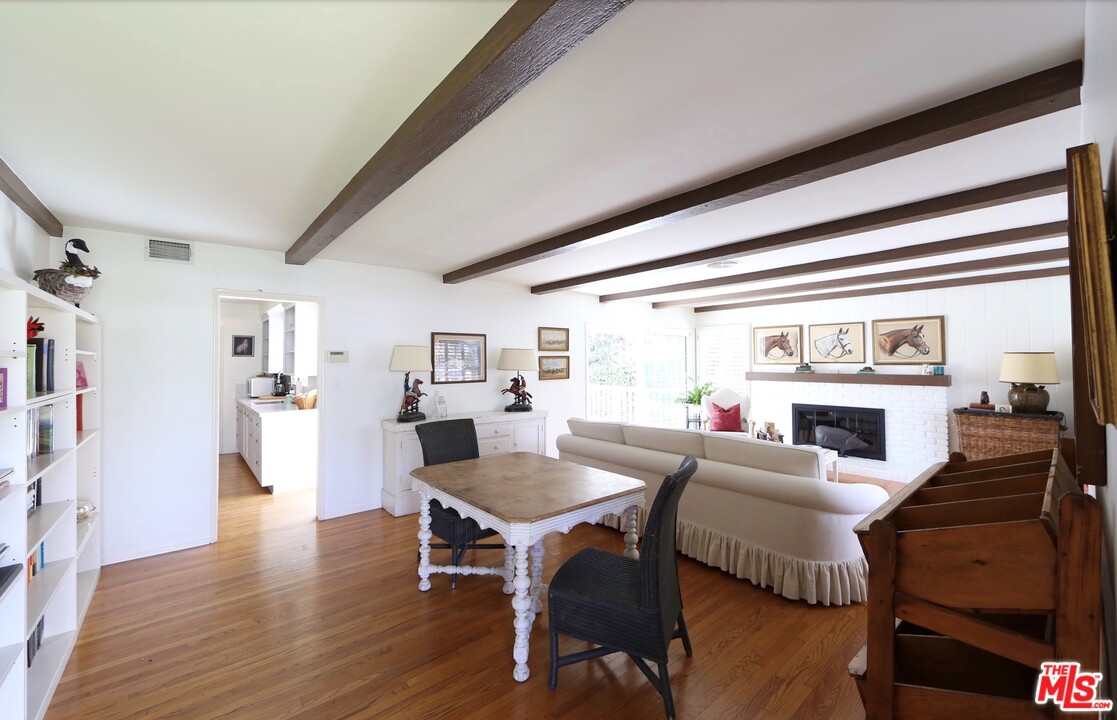 16948 Bollinger Drive Pacific Palisades, CA 90272 - Photo 2 of 5 a living room with fireplace furniture and a large window