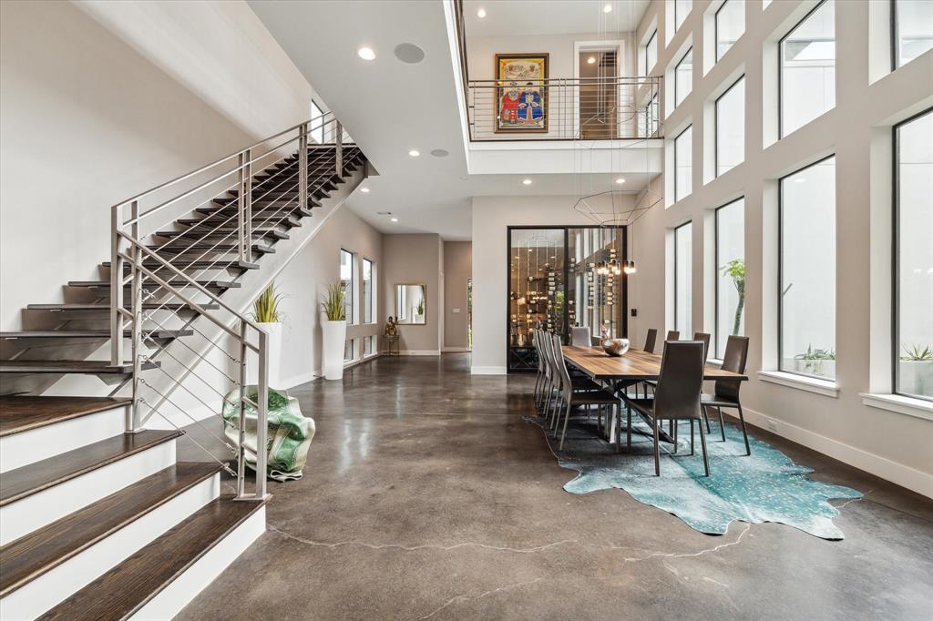 A floating hardwood staircase with stainless steel cables and handrails is a focal point and dramatic backdrop for the first and second floor.
