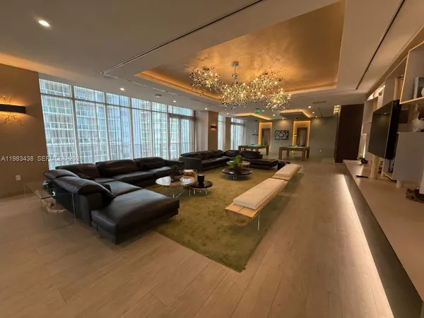 a living room with furniture a flat screen tv and a large window