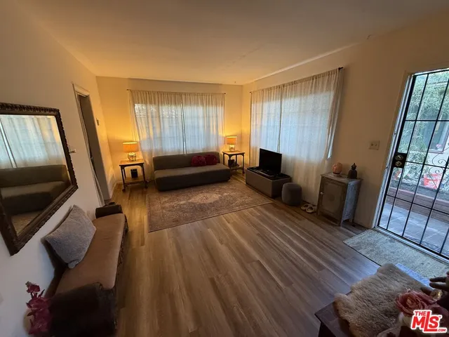 a living room with furniture and a wooden floor