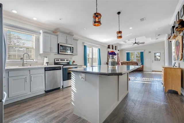 a kitchen with counter top space and wooden floor