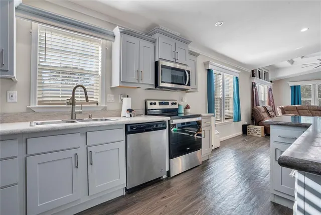 a kitchen with white cabinets and appliances