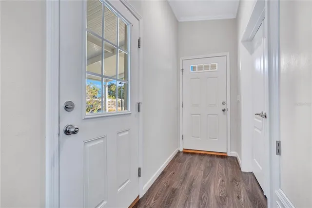 a view of a hallway with wooden floor and a window