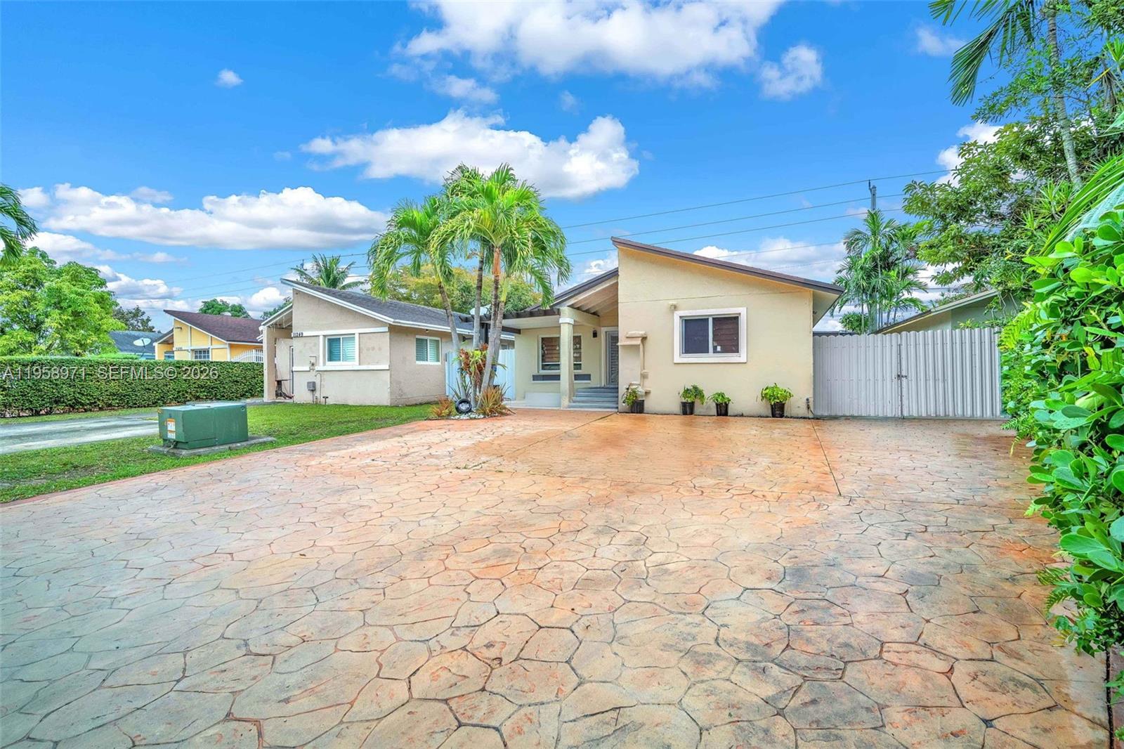 11245 Southwest 155th Lane Miami, FL 33157 - Photo 2 of 30 a view of yellow house with a yard and potted plants