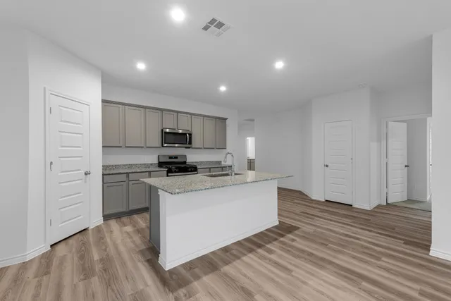 a kitchen with a refrigerator and a stove top oven