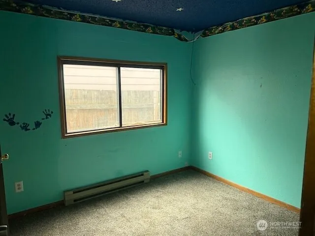 a view of an empty room with a window and a ceiling fan