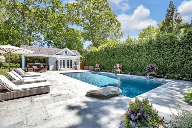 a view of house with garden and swimming pool