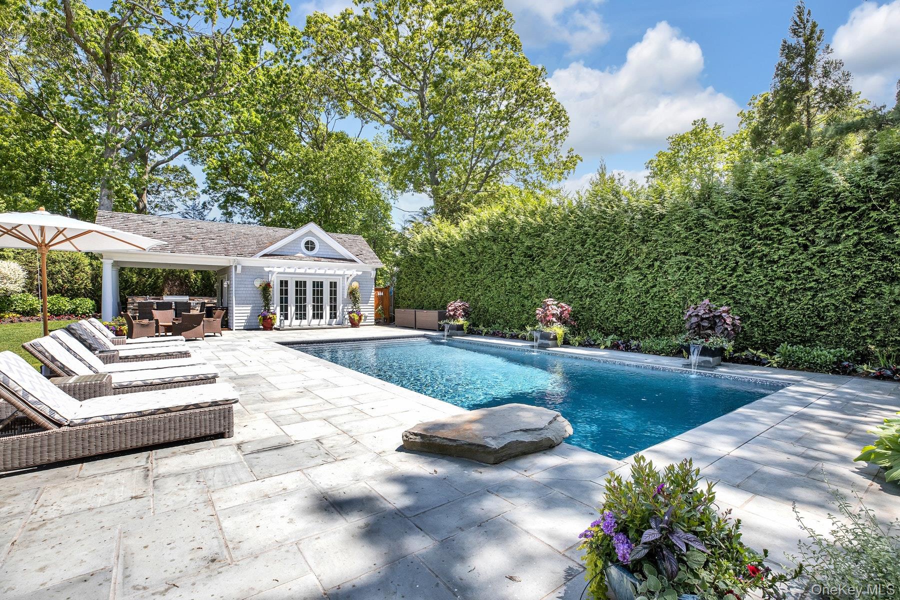 a view of house with garden and swimming pool