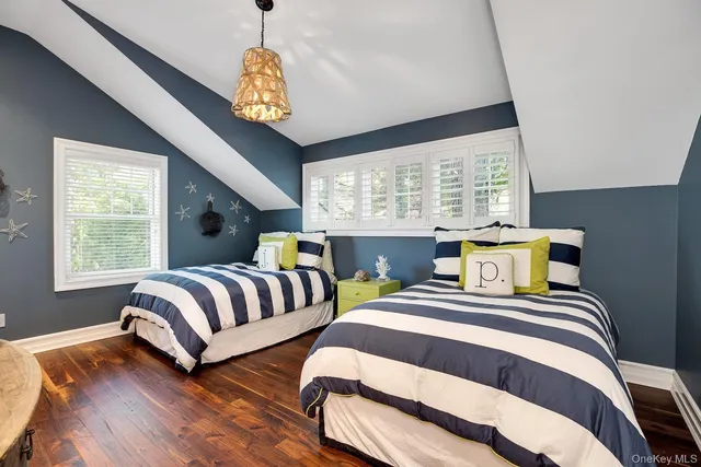 a bedroom with two beds and a large window