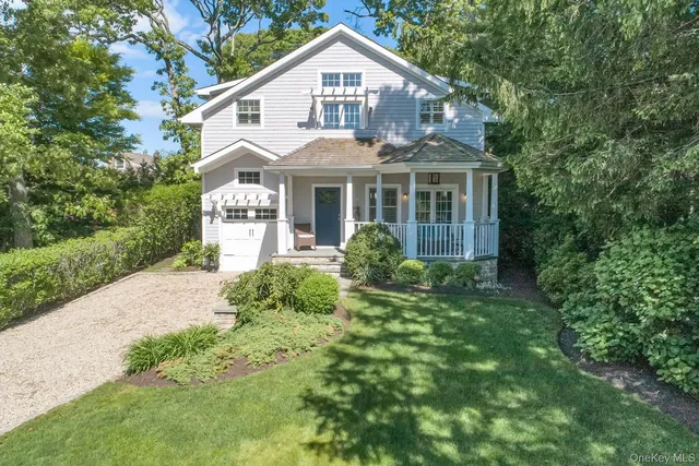 a front view of a house with a yard and potted plants