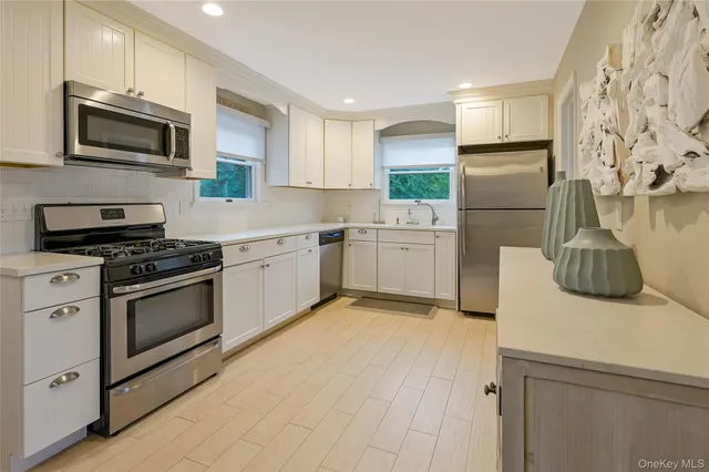 a kitchen with white cabinets and stainless steel appliances