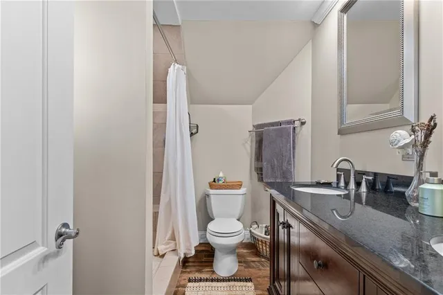 a bathroom with a granite countertop toilet a sink and shower