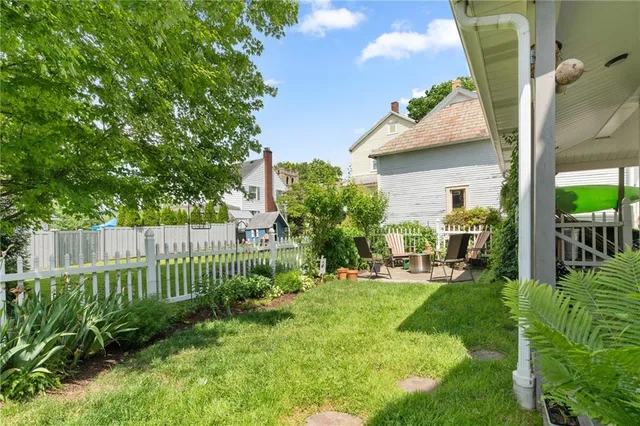 a view of a chair and table in back yard of the house