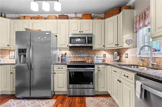 a kitchen with stainless steel appliances granite countertop a stove a refrigerator and a microwave